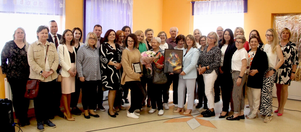 Grupa bibliotekarzy i przyjaciół bibliotek pozuje do zdjęcia zbiorowego